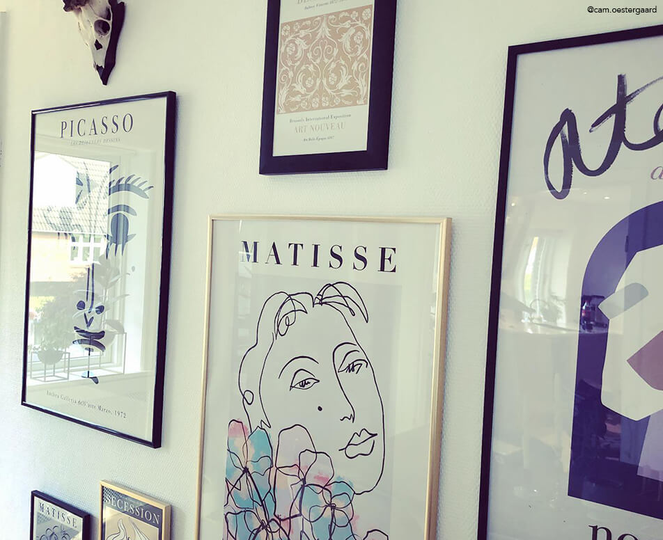 Mur d'images avec cadres noirs et cadres dorés